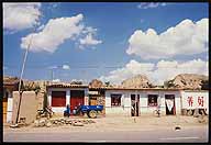 Dwellings and shops along the road :: A Strip Village